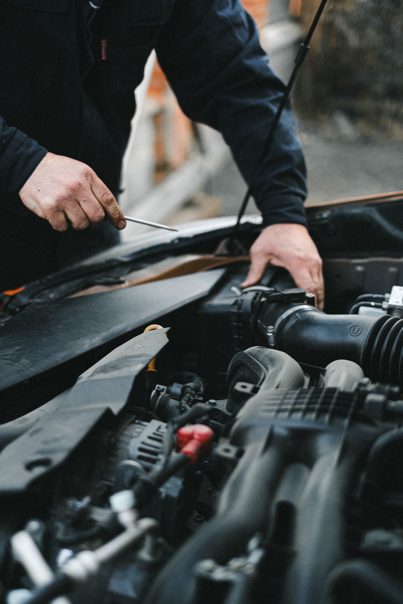 Automotive technician inspecting and repairing a car engine